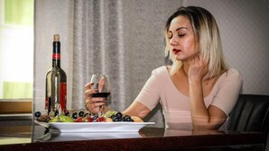A person seated at a table with a bottle of wine, a glass of wine, and a plate of fruit. - Safran Hotel (Baku)