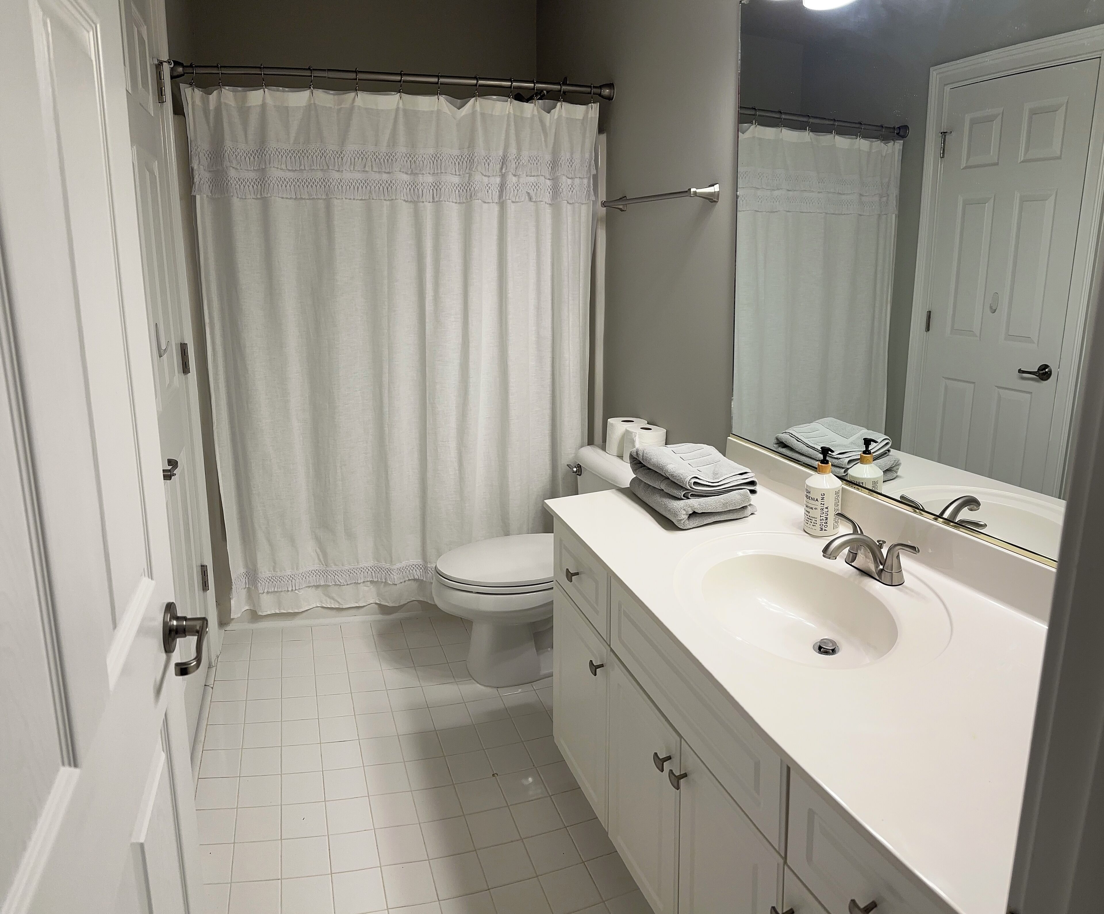 Un baño con inodoro, lavabo y espejo.