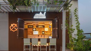 A bar and grill named Aravali with a wooden facade, a variety of liquor bottles, and outdoor seating. - Doubletree by Hilton Jaipur Amer (Amer)