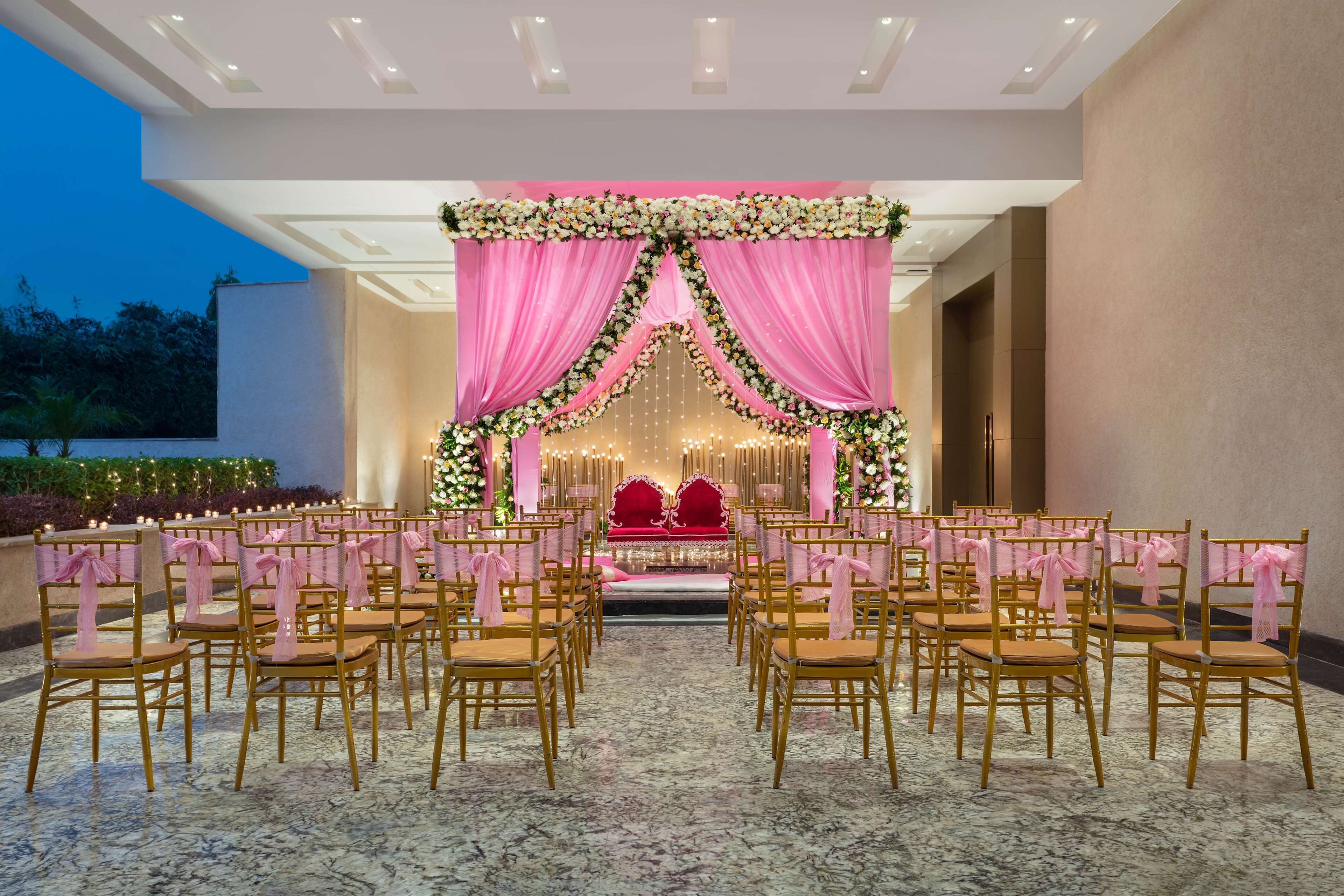 A formal event setup with rows of chairs and a stage with floral decorations.
