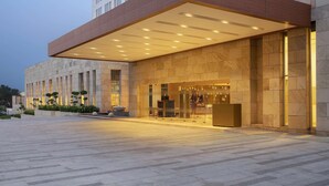 A modern building with a large entrance, a covered walkway, and a well-lit facade. - Doubletree by Hilton Jaipur Amer (Amer)