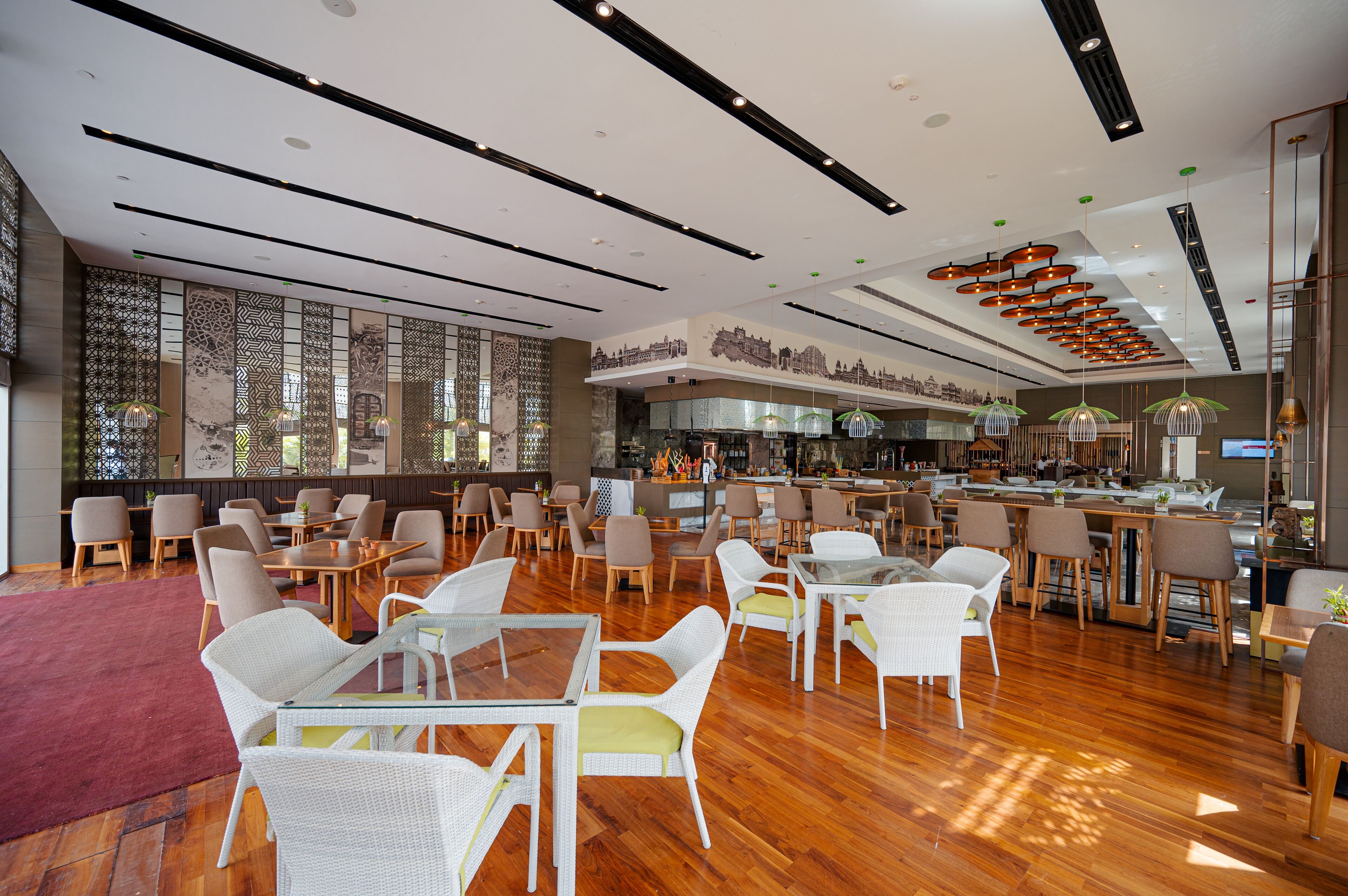 A spacious restaurant with high ceilings, modern lighting, and a variety of seating options including tables and chairs.
