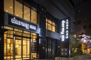 A modern building with large windows and illuminated signage. - Dormy Inn Kobe Motomachi Natural Hot Springs (Kobe)