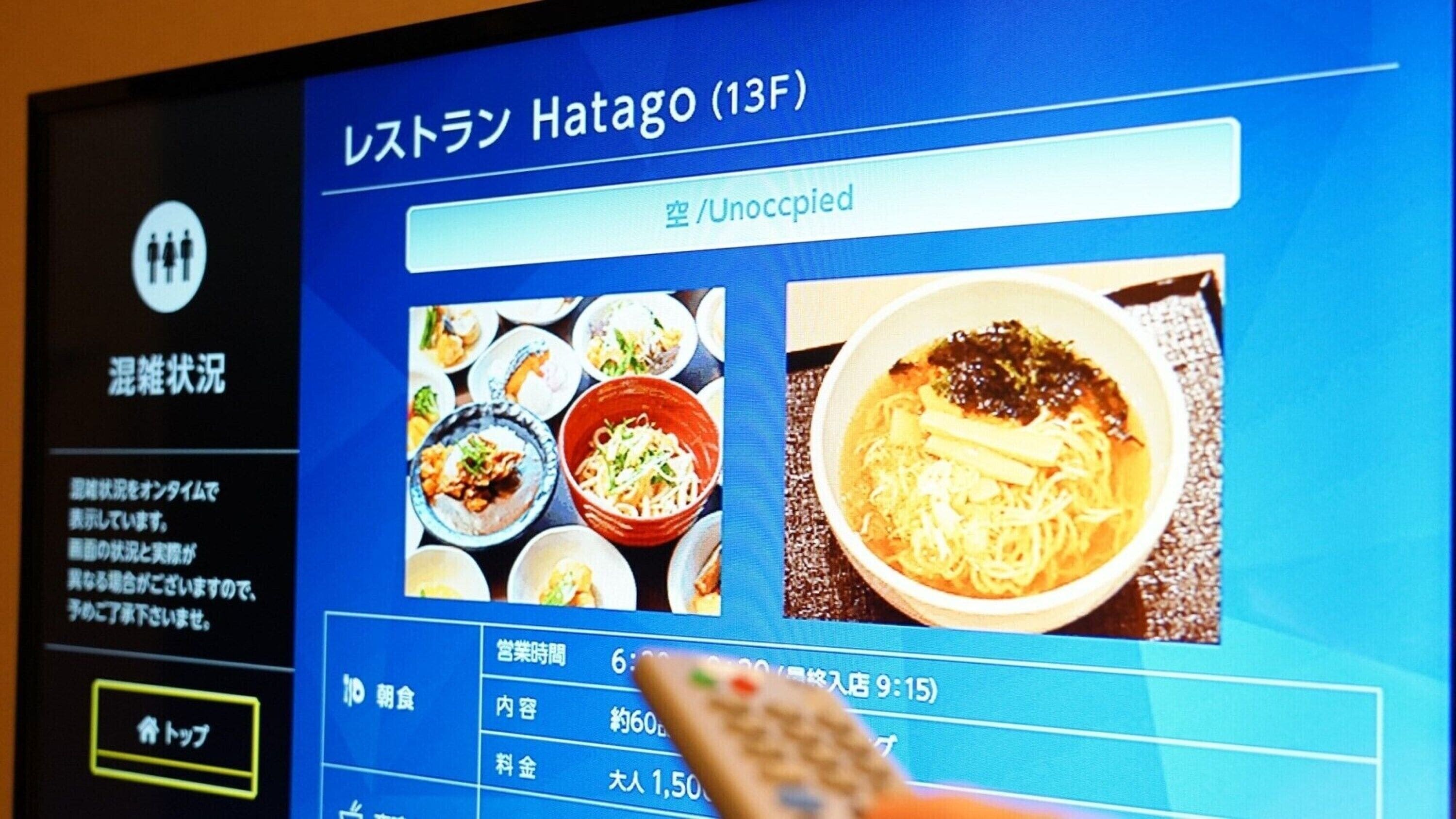 A digital menu display for a restaurant named "Restroom Hatago (13F)" with various dishes and a noodle dish prominently featured.