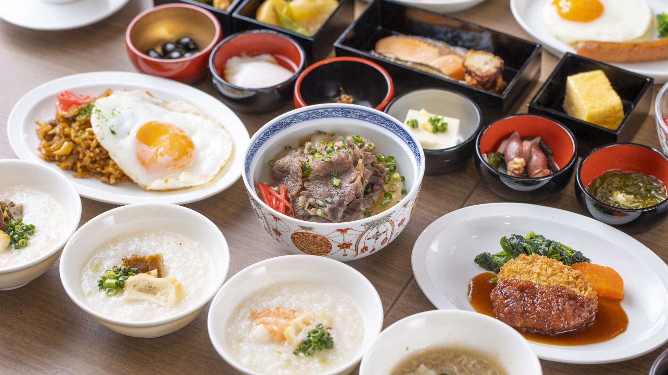 A variety of dishes including rice, soup, and meat, arranged on a table.