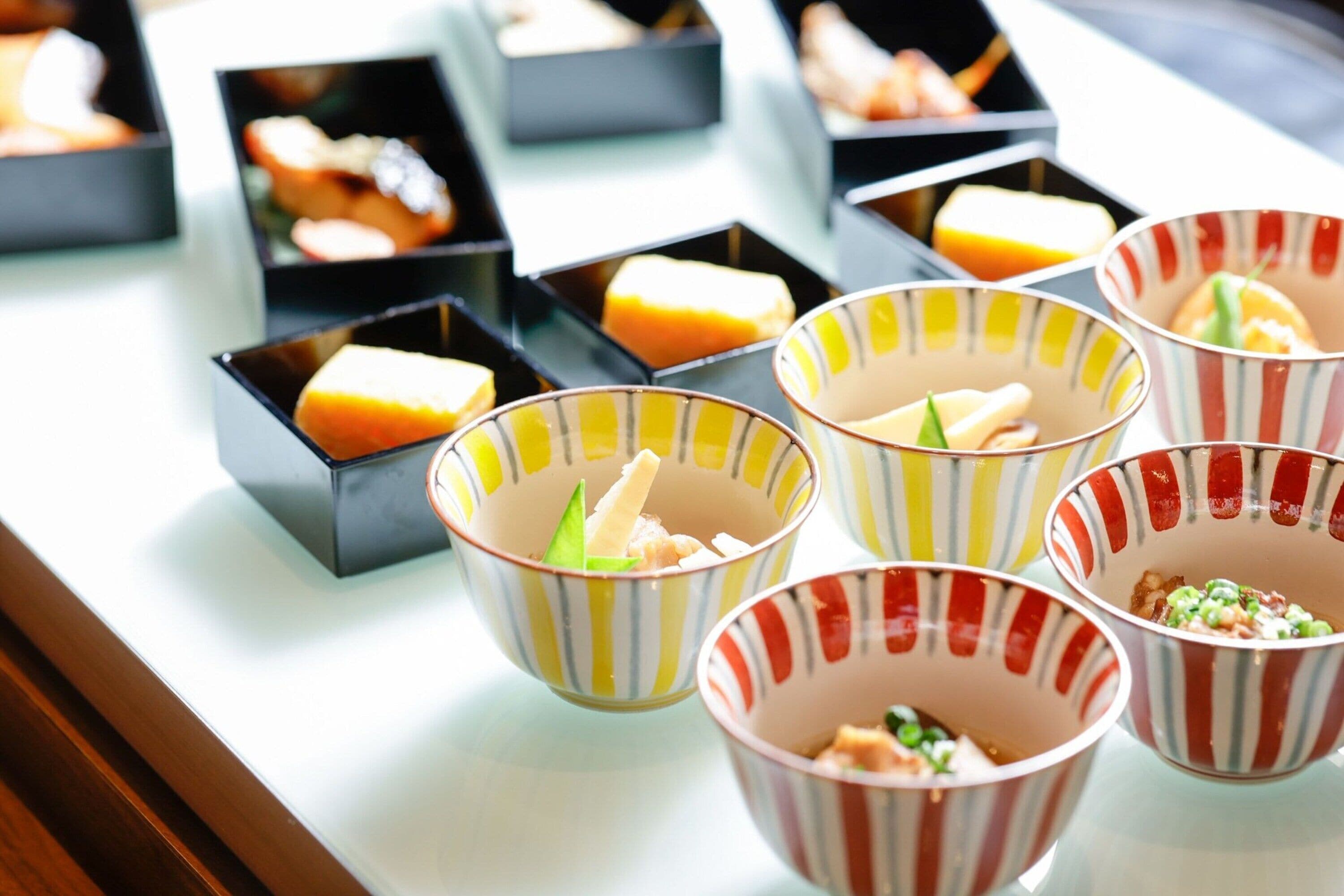 Diversos alimentos em pequenas embalagens, possivelmente parte de um buffet ou serviço de catering.