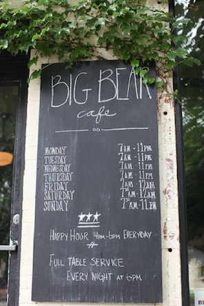A chalkboard menu for Big Bear Cafe, listing operating hours and services.