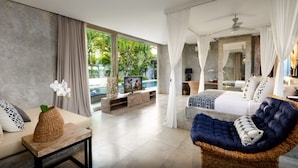 Ein modernes Schlafzimmer mit großem Fenster, einem Bett, einer Couch und einem Korbstuhl.