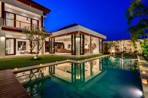 Una piscina al aire libre, sillones reclinables de piscina