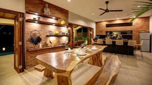 Une cuisine moderne avec un mur en briques, une table en bois et des tabourets de bar.