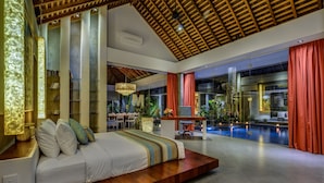 Una habitación de hotel moderna con una cama grande, un comedor y una piscina.