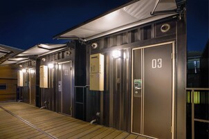 Una fila de puertas de ascensor metálicas con los números 02 y 03, indicando un hotel o alojamiento similar.