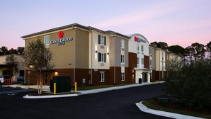 Um hotel com design moderno, exibindo um logotipo e sinalização que identificam o local como Candlewood Suites.