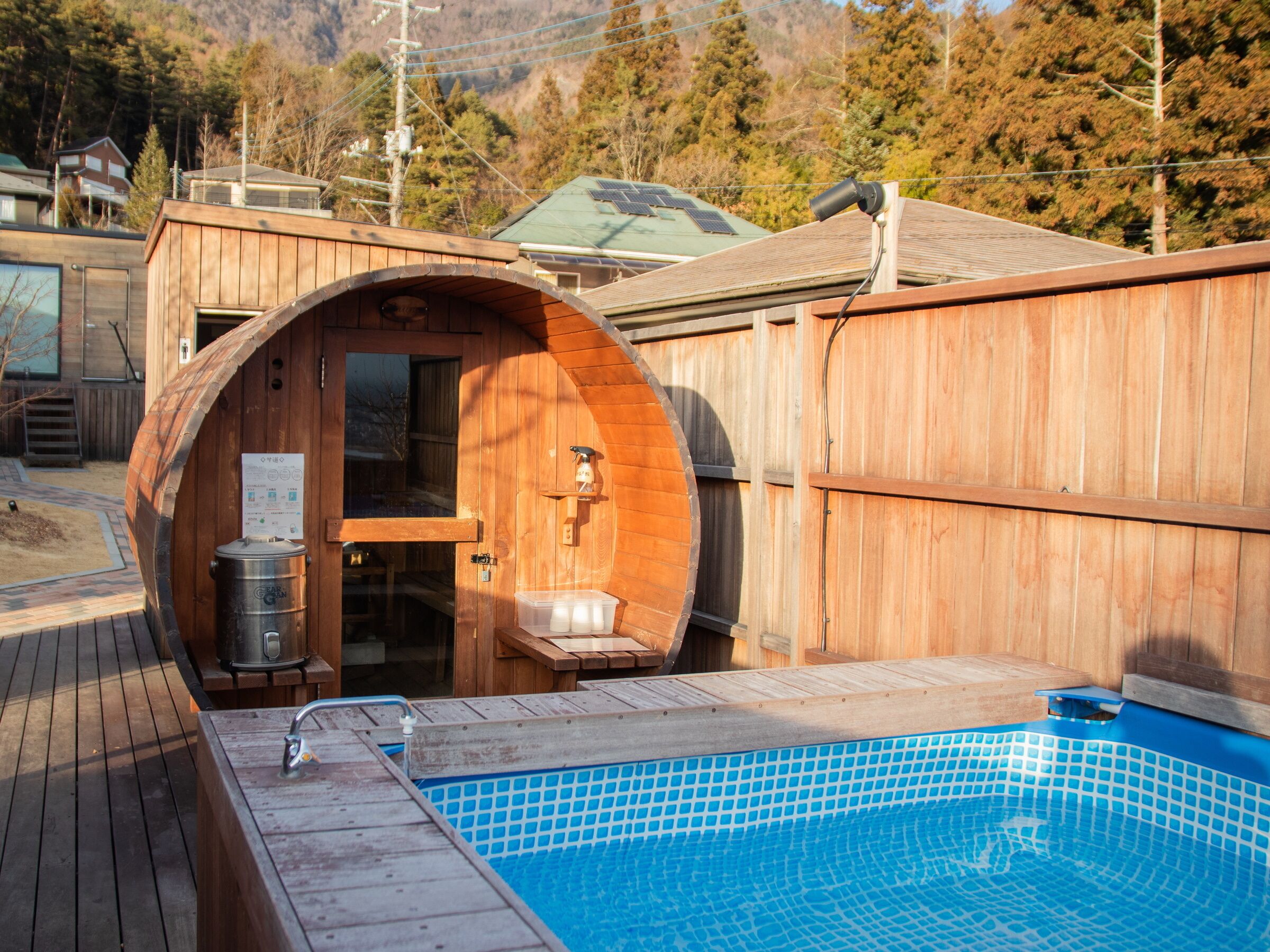 A wooden sauna with a glass door, a wooden bench, and a small table.