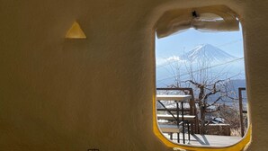 A view through a window of a building with a mountain in the background. - Dot Glamping Fujisan (Fujikawaguchiko)