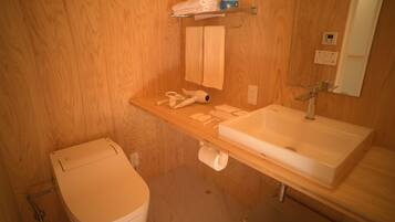 A bathroom with a wooden vanity, a sink, a toilet, and a towel rack.