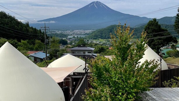 A view of a mountain with a small town in the foreground. - Dot Glamping Fujisan (Fujikawaguchiko)