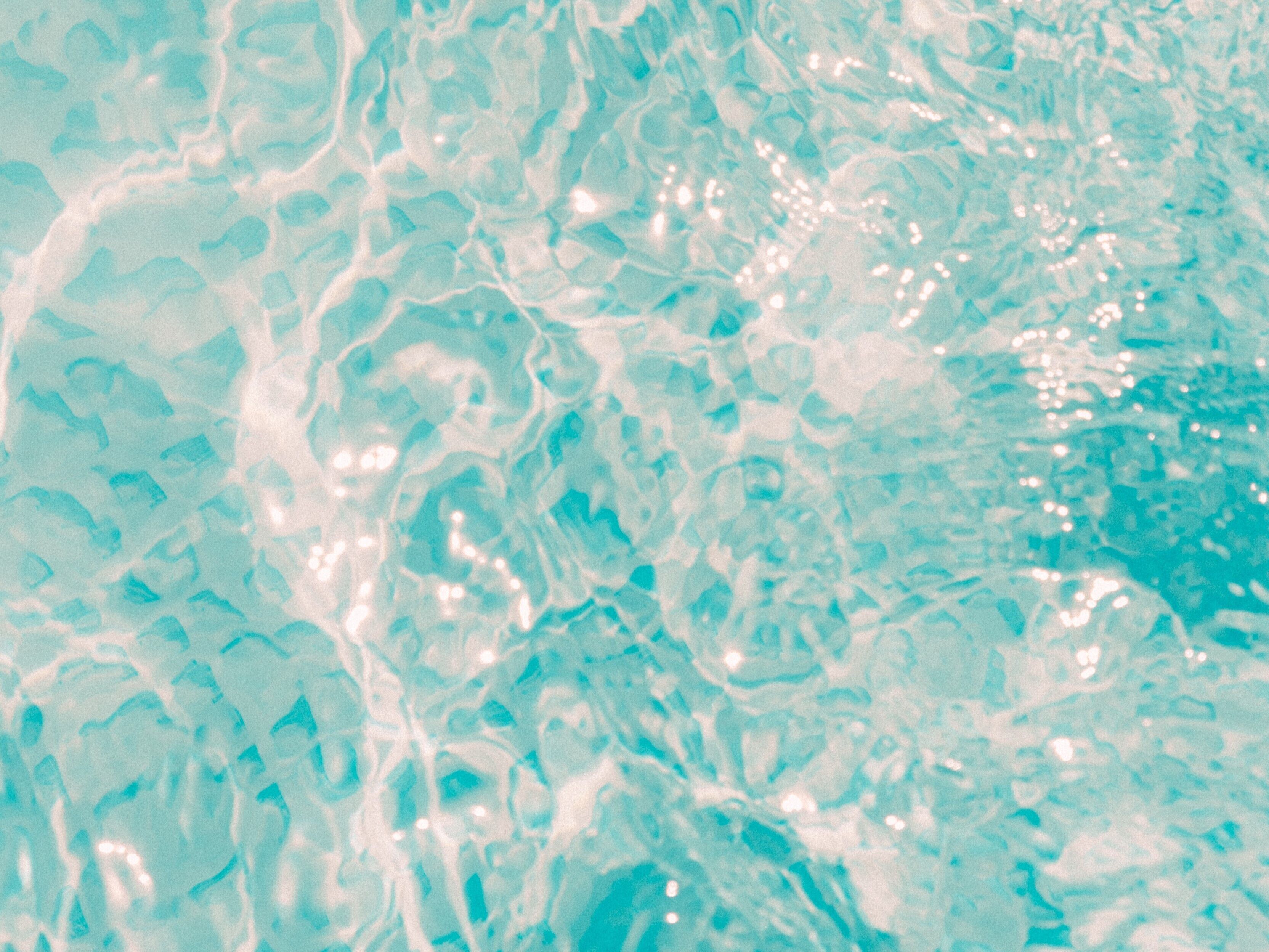 A close-up of water with light reflections and ripples.