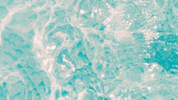A close-up of water with light reflections and ripples.