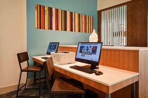 Una reception hotel con due computer, una stampante e un distributore di fazzoletti.