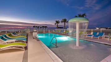 A pool area with lounge chairs and a water feature.
