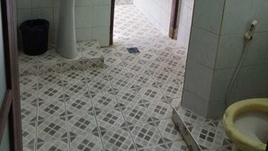 Un baño con lavabo, espejo, inodoro y suelo de baldosas.