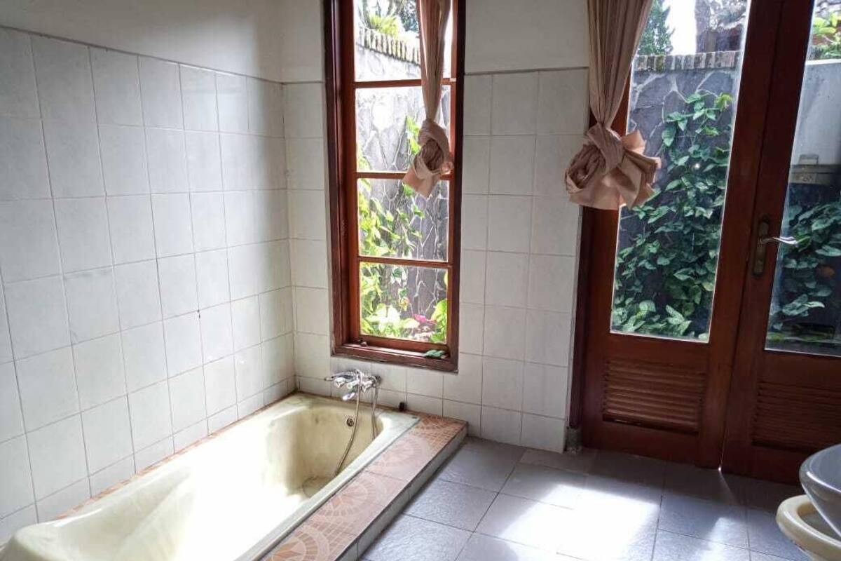 Een badkamer met een bad, een raam en een deur.