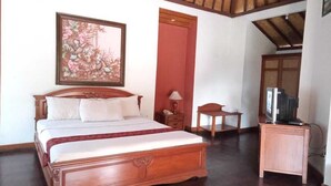 Un dormitorio con una cama grande, una mesita, un televisor y una obra de arte enmarcada en la pared.