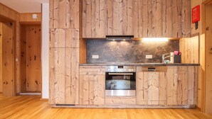 A kitchen with wooden cabinetry, a stainless steel oven, and a built-in microwave. - moderne Ferienwohnung/Dalaas (Dalaas)