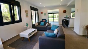 A modern living room with a sofa, coffee table, and a dining area with chairs. - Discover Andalusia in a different way - the protected and authentic Atlantic coast (conil de la frontera)