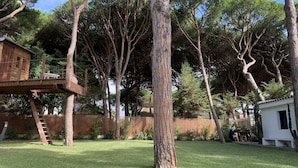 A backyard with a wooden deck, a ladder, and a white building. - Discover Andalusia in a different way - the protected and authentic Atlantic coast (conil de la frontera)