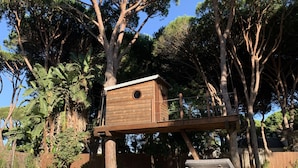 A poolside area with a wooden birdhouse on a platform, lounge chairs, and a clear blue sky. - Discover Andalusia in a different way - the protected and authentic Atlantic coast (conil de la frontera)