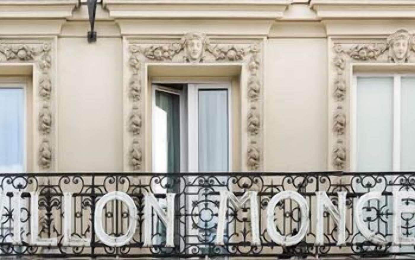 Fachada de edificio con detalles arquitectónicos ornamentales y un balcón con el nombre 'LION MONCE' en letras de metal.