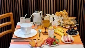 A breakfast table with a variety of food items, a coffee pot, and a glass of orange juice. - Hotel Pavillon Monceau by Happy Culture (Paris)