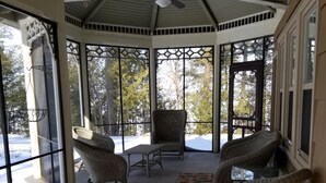 A covered outdoor seating area with wicker furniture, large windows, and a ceiling fan. - BEAUTIFUL FOUR SEASON WATERFRONT COTTAGE (Innisfill)