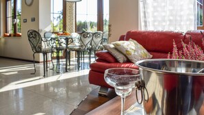 Un salon avec un canapé rouge, une table en verre et un seau en métal.