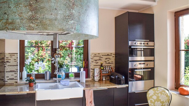 Une cuisine moderne dotée d’un four encastré et d’une grande fenêtre.