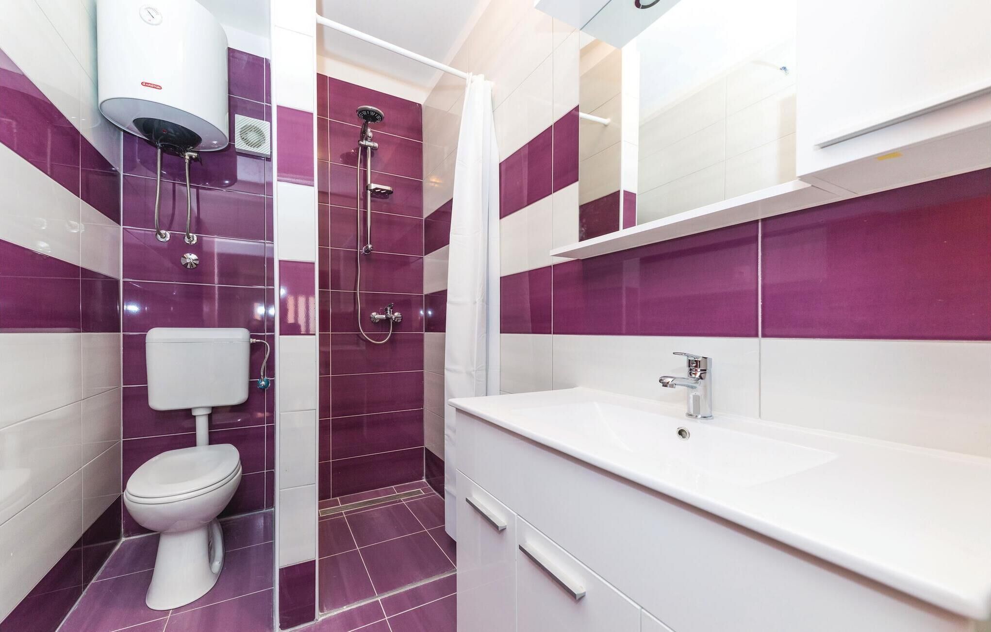 Une salle de bain moderne équipée de toilettes, d’une douche et d’un lavabo.