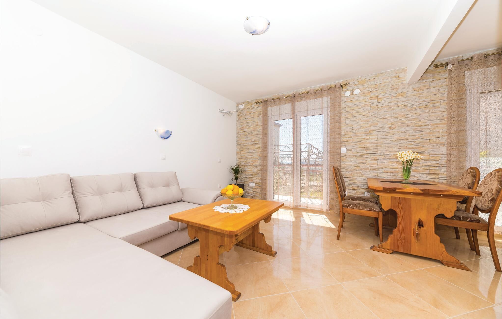 A living room with a sofa, a wooden coffee table, and a dining table with chairs.