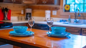 A kitchen counter with two blue bowls and two glasses of water. - The Ossi is a secluded couples cabin with panoramic mountain and sunset views! (Smithville)