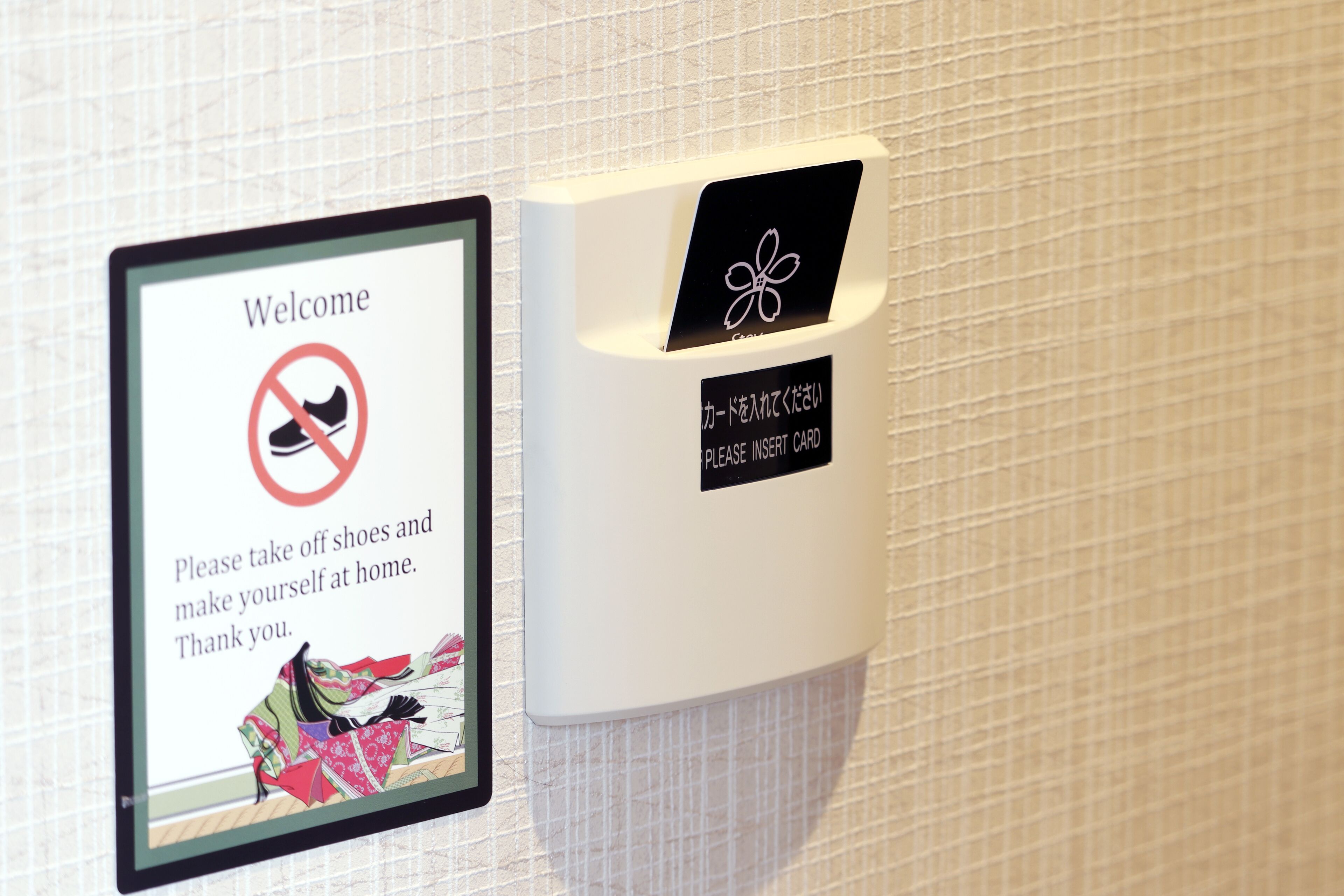 A welcome sign with a shoe icon crossed out, instructing guests to remove shoes and make themselves at home.
