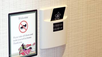 A welcome sign with a shoe icon crossed out, instructing guests to remove shoes and make themselves at home.