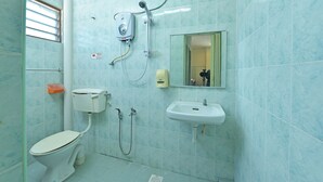 Une salle de bain avec des toilettes, un lavabo et une douche.