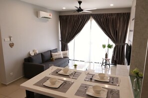 A modern living room with a dining area set for four.