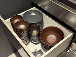 A drawer containing various bowls and plates, neatly stacked. - TABISAI Luxe (Fukuoka)