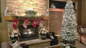Una sala de estar acogedora con chimenea, un árbol de Navidad y calcetines festivos.