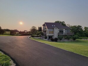 A two-story house with a driveway and a lawn. - 5 BR en suite with firepit, hot tub,and game room. (Galena)