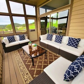 A covered patio area with a sofa set, a coffee table, and a patterned rug. - 5 BR en suite with firepit, hot tub,and game room. (Galena)