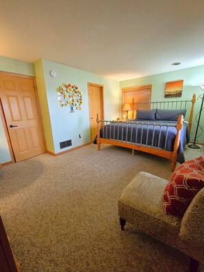A bedroom with a bed, a chair, a door, and a wall decoration. - 5 BR en suite with firepit, hot tub,and game room. (Galena)