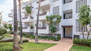 A modern multi-story building with balconies, a paved entrance, and surrounding greenery. - Awesome apartment in Estepona with WiFi (Estepona)